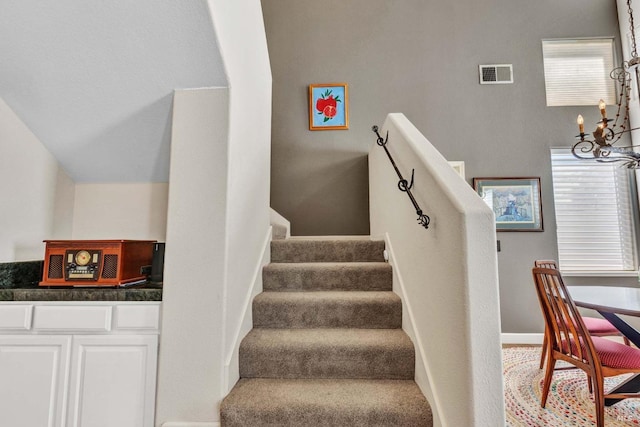 stairway featuring an inviting chandelier