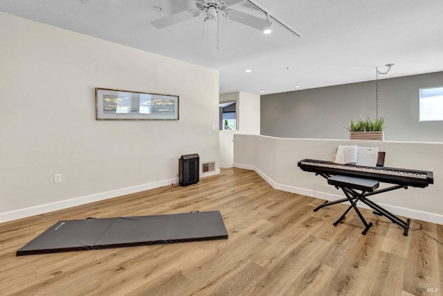 workout room featuring track lighting and light hardwood / wood-style floors