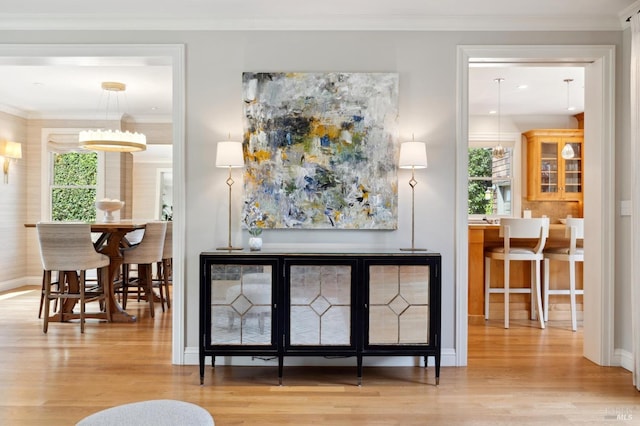 dining space featuring crown molding and light hardwood / wood-style flooring