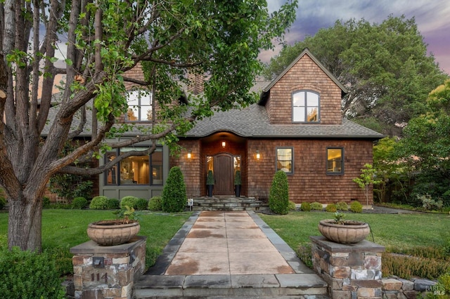 view of front of property featuring a front lawn and roof with shingles