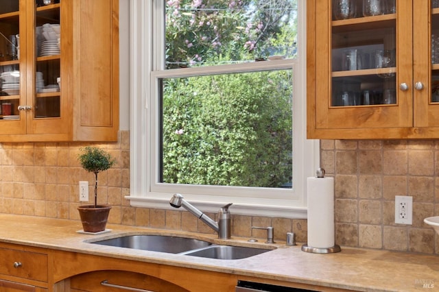 114 Van Tassel Ct, San Anselmo, CA 94960 - kitchen featuring light stone counters, backsplash, glass insert cabinets, and a sink