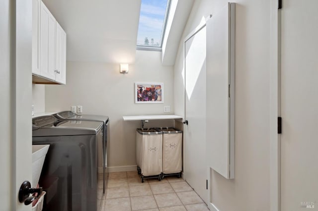 laundry room with cabinets, a skylight, washing machine and dryer, and light tile patterned flooring