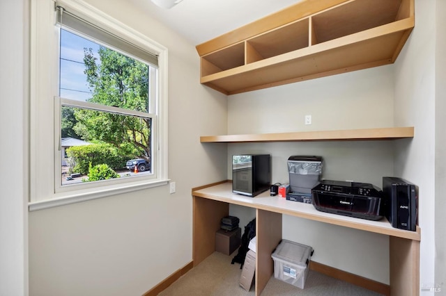 carpeted home office featuring built in desk