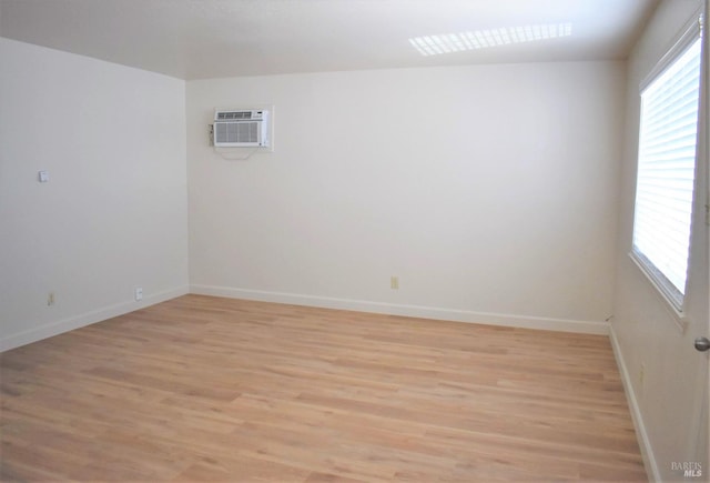 unfurnished room featuring light hardwood / wood-style flooring and a wall mounted air conditioner