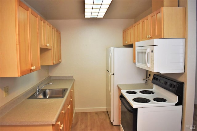 kitchen with light brown cabinetry, light hardwood / wood-style flooring, sink, and white appliances