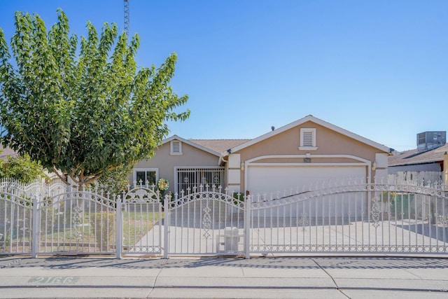 view of front of house with a garage, fence, driveway, a gate, and stucco siding