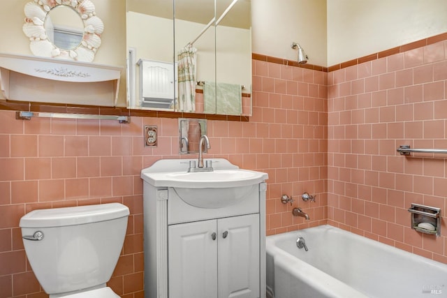 bathroom with toilet, tile walls, vanity, and shower / bath combination with curtain