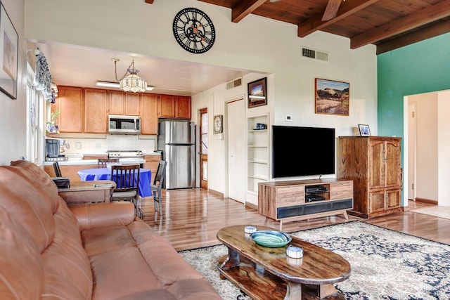 living room featuring light wood-type flooring, wood ceiling, visible vents, and beam ceiling