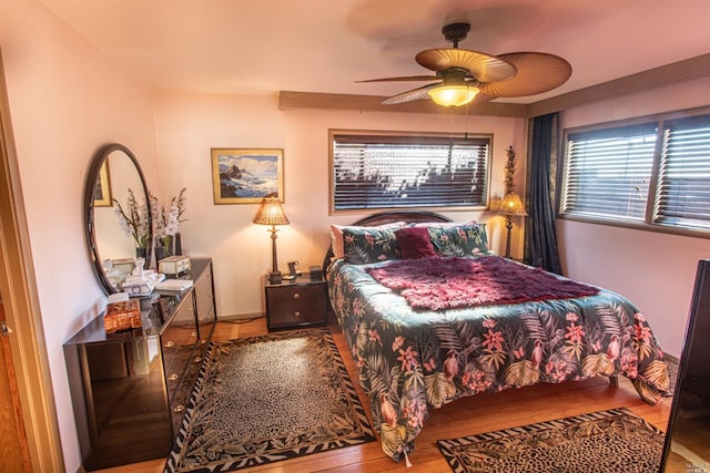 bedroom with ceiling fan, hardwood / wood-style flooring, and multiple windows