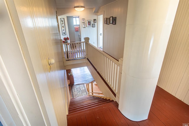 staircase featuring wood walls and hardwood / wood-style flooring