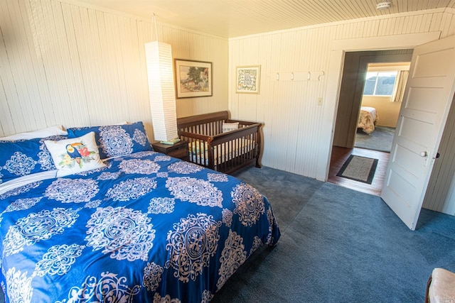 bedroom with dark carpet and wooden walls