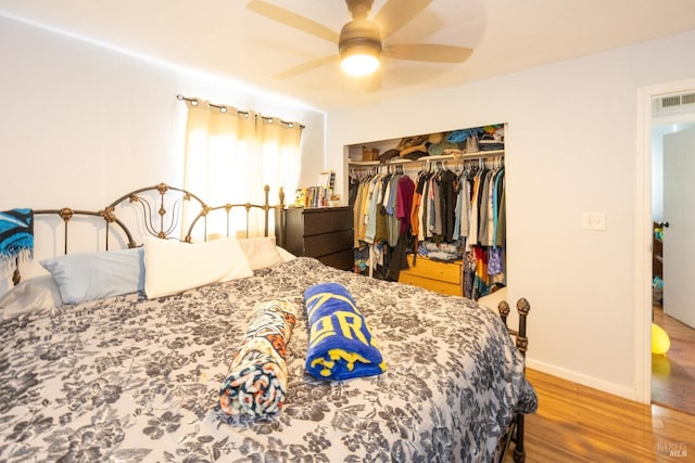 bedroom featuring hardwood / wood-style flooring, ceiling fan, and a closet