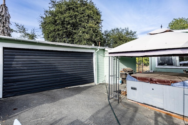 view of patio featuring a grill, a gazebo, and a garage