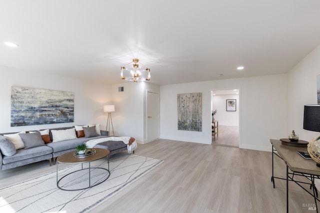 living room with a chandelier and light hardwood / wood-style floors