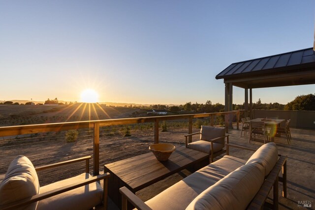 patio terrace at dusk featuring a deck and an outdoor living space