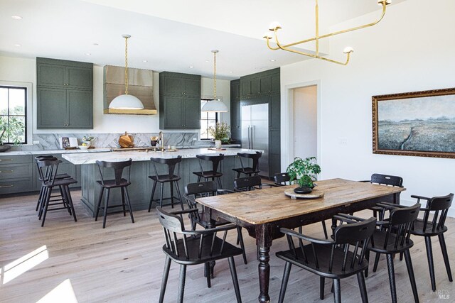 dining room featuring light hardwood / wood-style flooring, a notable chandelier, and sink