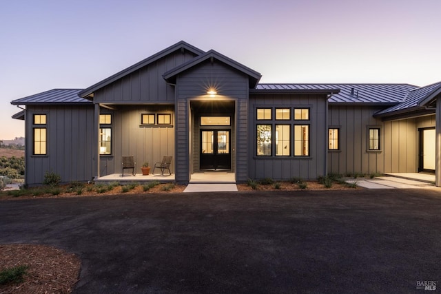 modern inspired farmhouse featuring board and batten siding, a standing seam roof, and metal roof