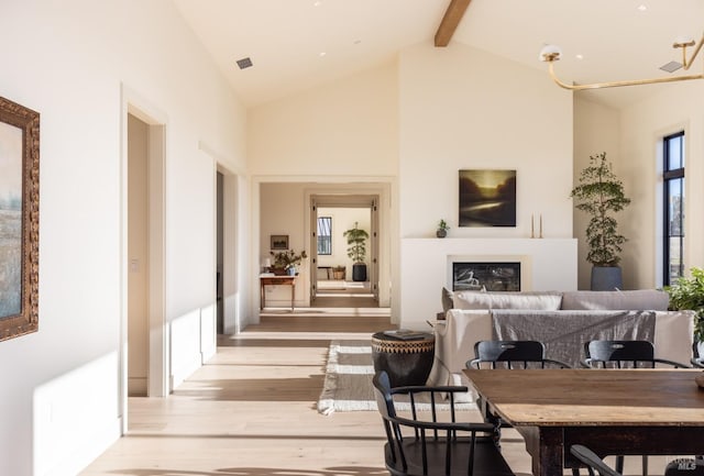 interior space featuring light hardwood / wood-style flooring, beam ceiling, and high vaulted ceiling