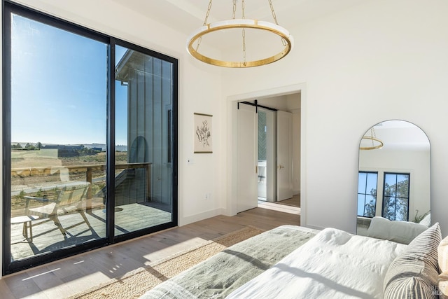 bedroom with hardwood / wood-style flooring and a barn door