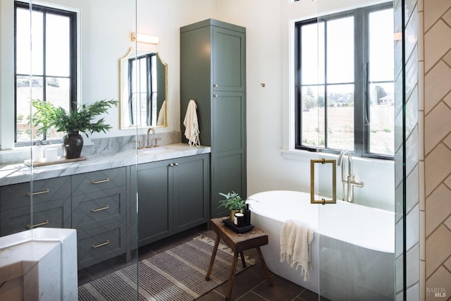 bathroom featuring vanity, tile patterned floors, and a tub