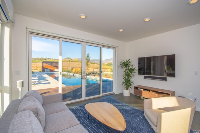 living room with hardwood / wood-style floors and a wall unit AC