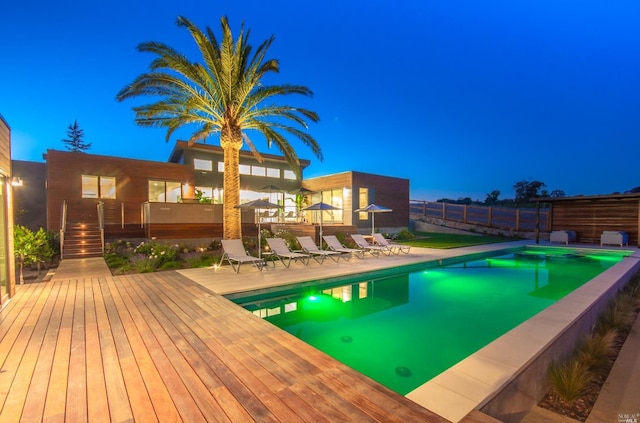 pool at night with a patio area