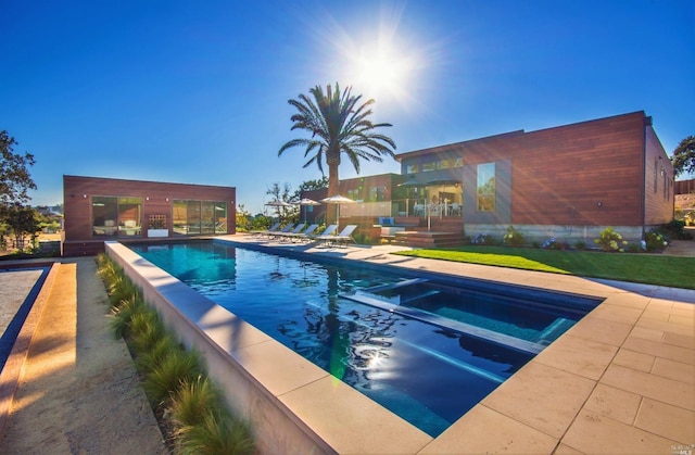 view of pool with a lawn and a patio