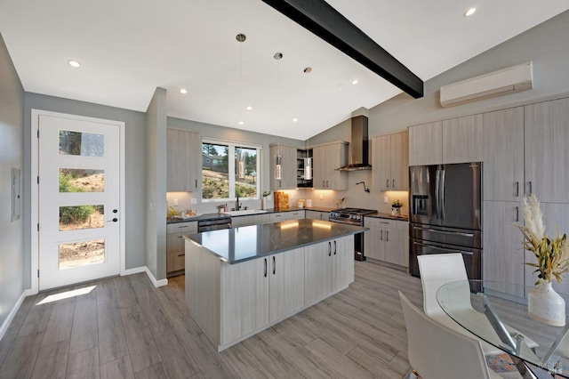 kitchen featuring a sink, an AC wall unit, appliances with stainless steel finishes, wall chimney range hood, and modern cabinets