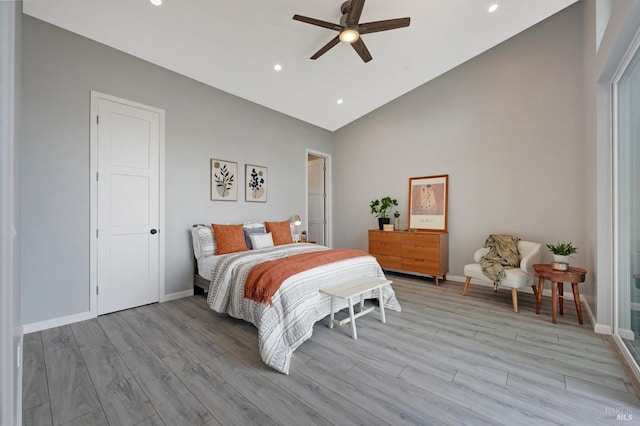 bedroom featuring lofted ceiling, baseboards, and light wood-style floors