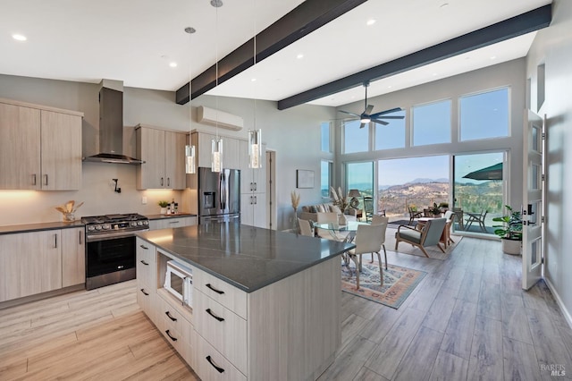 kitchen featuring light wood-type flooring, wall chimney range hood, modern cabinets, and appliances with stainless steel finishes