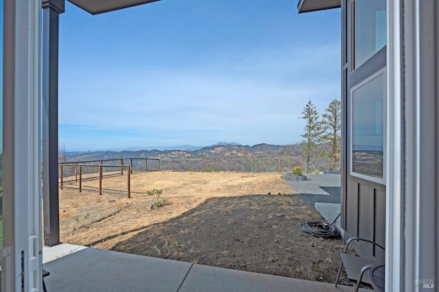 view of yard with a mountain view and fence