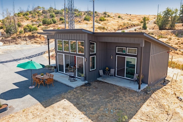 back of property with a patio and board and batten siding