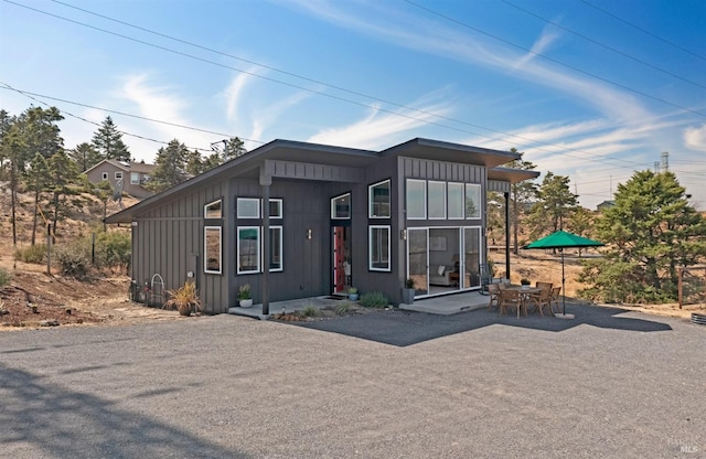 modern home with board and batten siding and a patio area