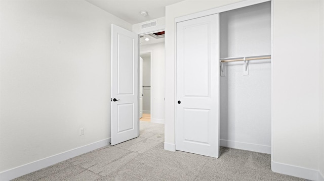 unfurnished bedroom with light carpet and a closet