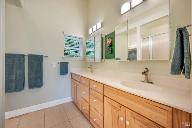 full bath with tile patterned floors, double vanity, a stall shower, and a sink