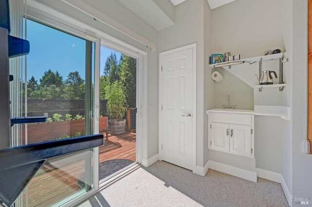 doorway featuring light colored carpet and sink