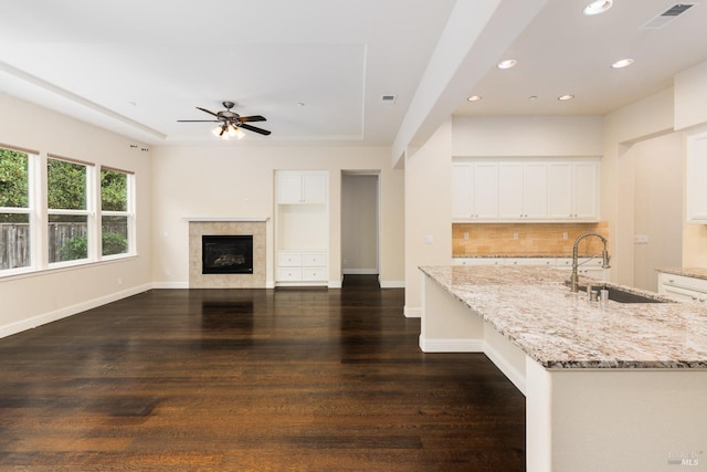 kitchen featuring white cabinetry, dark hardwood / wood-style floors, light stone counters, and sink