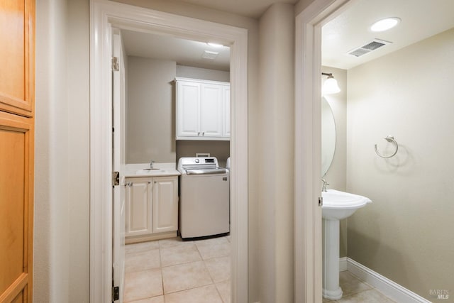 bathroom featuring washer / clothes dryer, sink, and tile patterned flooring