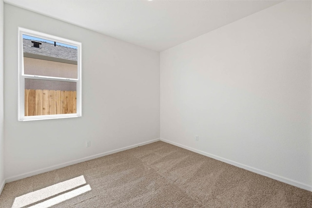 unfurnished room featuring carpet and baseboards