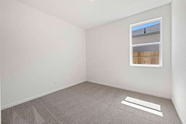 carpeted empty room featuring baseboards