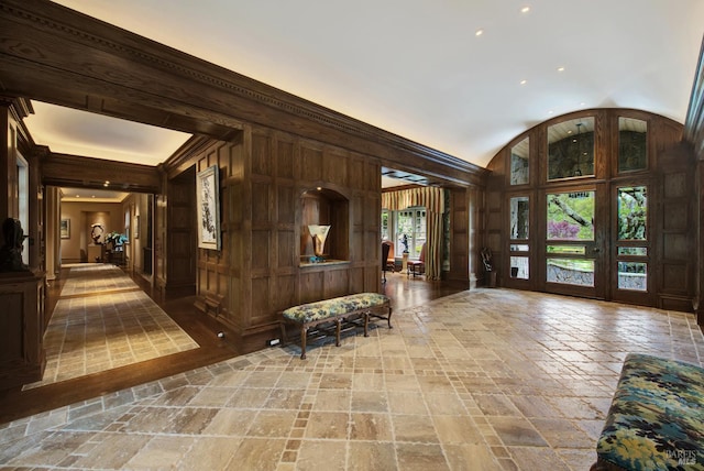 entryway with wooden walls and ornamental molding