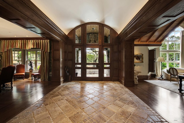 foyer with vaulted ceiling, hardwood / wood-style flooring, and crown molding