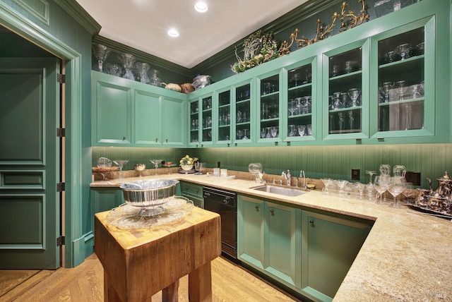 interior space with crown molding, light stone countertops, green cabinets, and sink