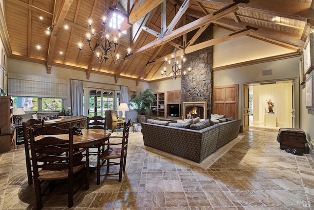 dining room with high vaulted ceiling, an inviting chandelier, and a fireplace