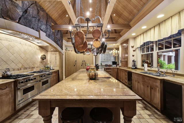 kitchen with a chandelier, beamed ceiling, premium range, and wine cooler