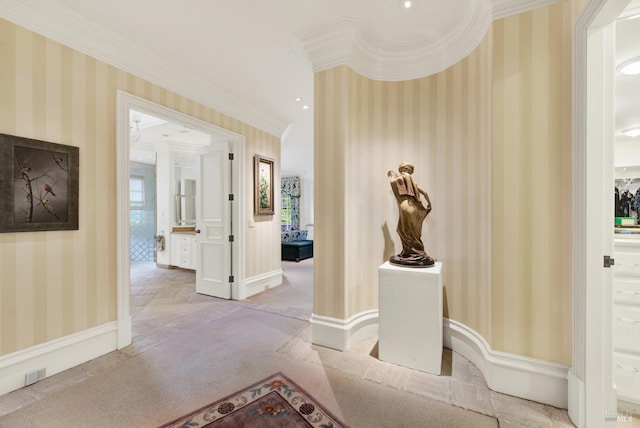 hallway with crown molding and light colored carpet