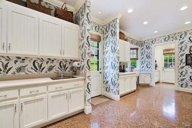 kitchen with crown molding, sink, and white cabinetry