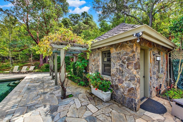 view of patio featuring an outdoor structure and a pergola