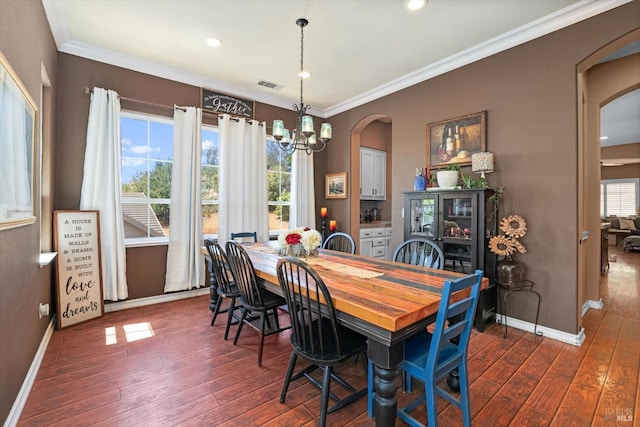 dining space featuring a healthy amount of sunlight, ornamental molding, dark hardwood / wood-style flooring, and a chandelier