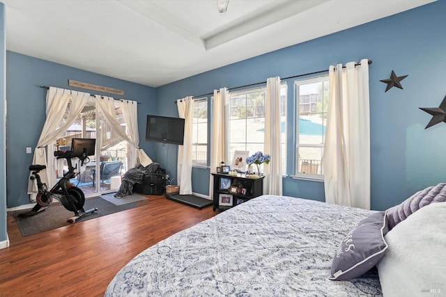 bedroom with multiple windows and dark wood-type flooring